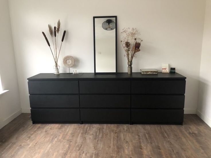 a large black dresser sitting on top of a hard wood floor