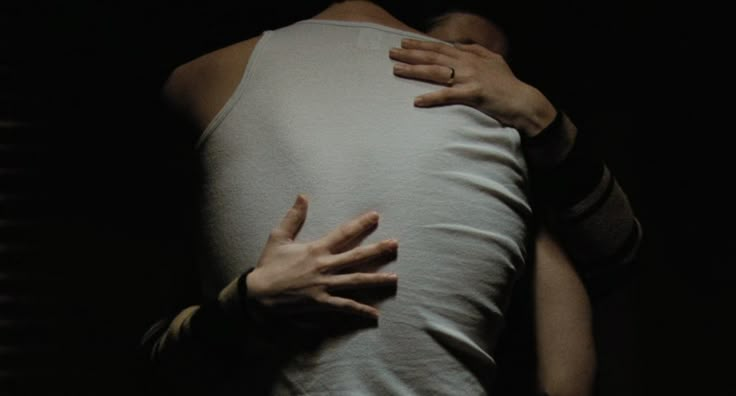 two hands on the back of a person's body, with their arms wrapped around each other