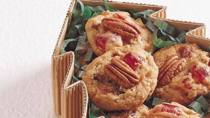 a box full of cookies with pecans and leaves on the top, sitting on a table