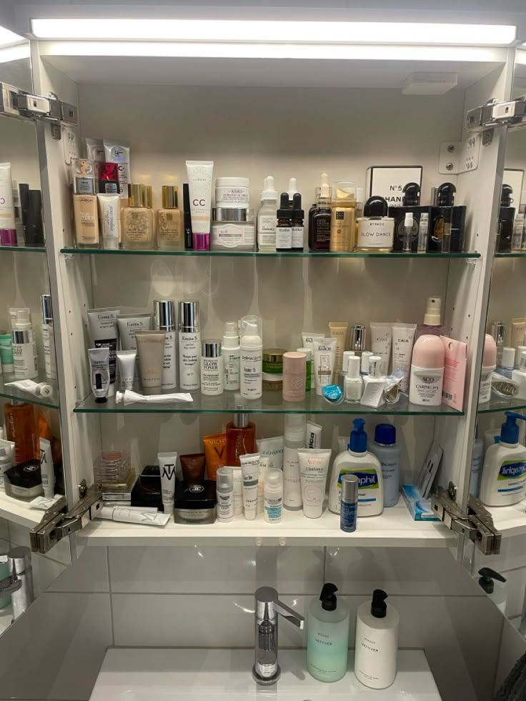 a bathroom sink filled with lots of different types of cosmetics and personal care products on shelves