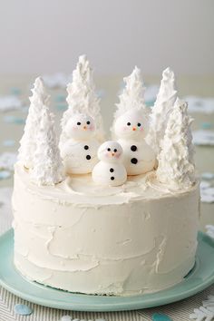 a white cake with snowmen on top and the words snowman meringue cake above it