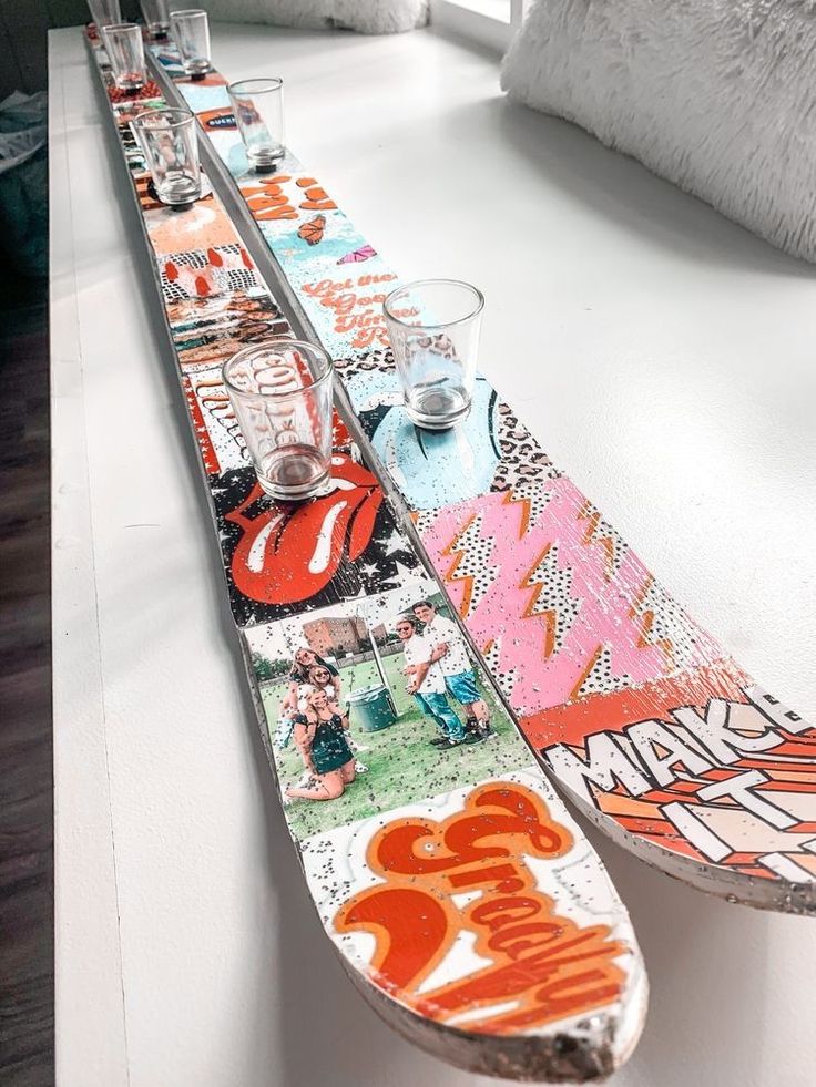 a skateboard is sitting on top of a table with glasses in front of it