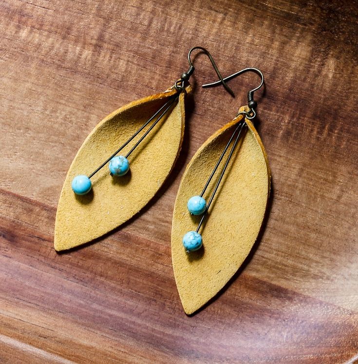 "Add a pop of color with these lightweight statement suede leather earrings featuring a curved leaf shape in yellow with turquoise accents. Additional colors available upon request. Nickel-free hardware. 3\" drop. See a similar style and additional colors here: https://etsy.me/2P9SJww" Leather Leaf Earrings, Leather Jewelry Making, Handmade Leather Jewelry, Diy Leather Earrings, Leather Jewelry Diy, Leather Leaf, Leather Diy Crafts, Turquoise Accents, Boho Leather