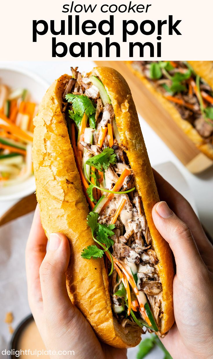 a person holding a sandwich in their hand with the text slow cooke pulled pork banh mi