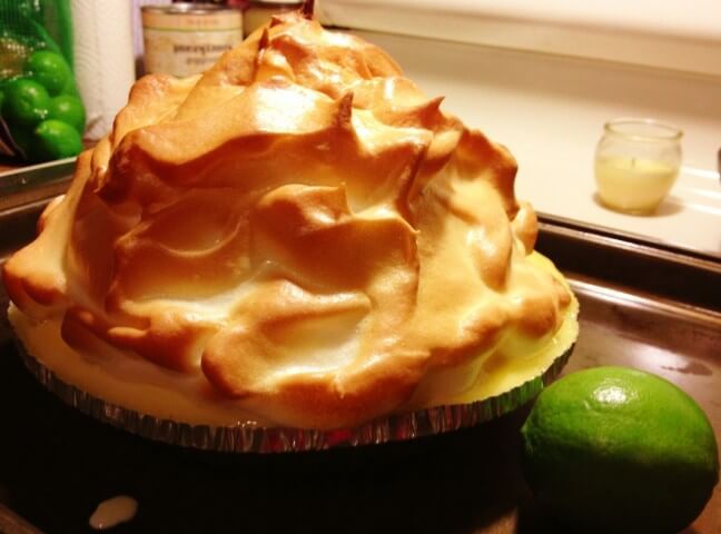 a pie sitting on top of a pan next to a lime