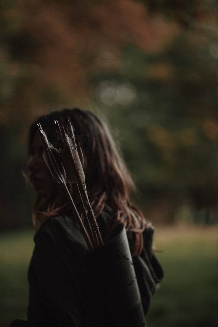 a woman holding two arrows in her hands