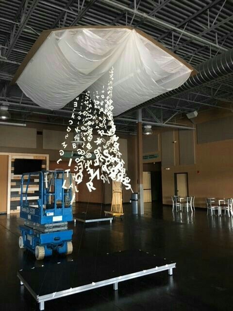 a large white christmas tree in an empty room with lots of chairs on the floor