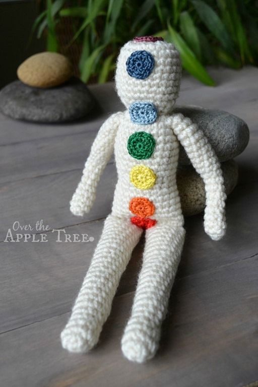 a crocheted toy sitting on top of a wooden table next to a potted plant