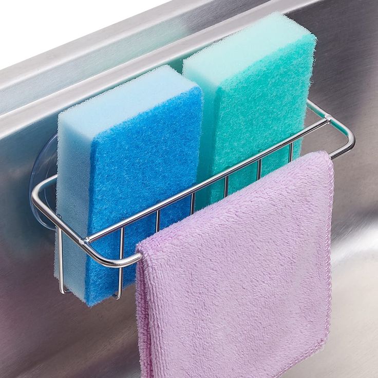 three sponges in a metal holder on the side of a stainless steel dishwasher