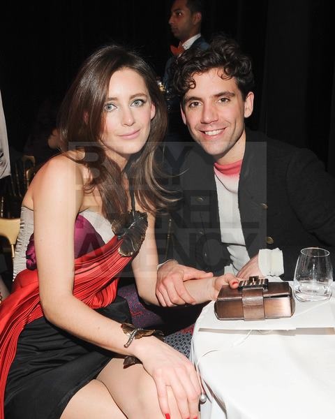 a man and woman sitting next to each other at a table