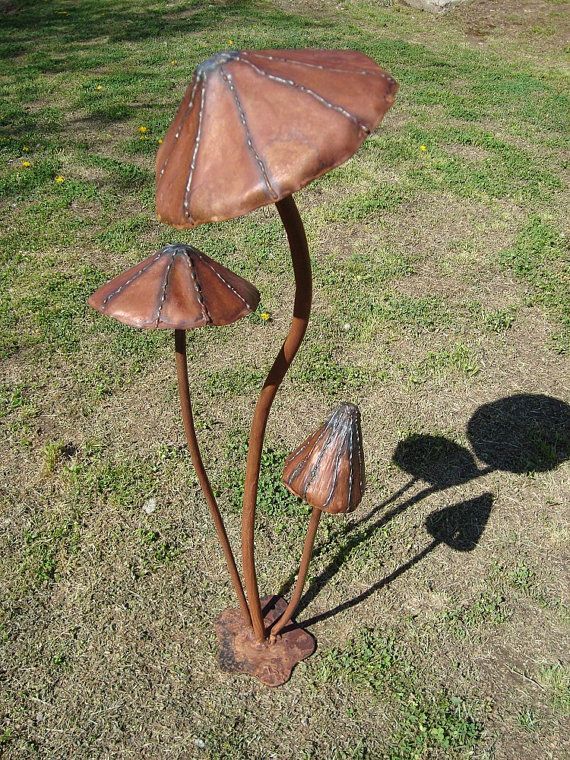 two metal lamps sitting on top of a grass covered field next to a shadow in the sun