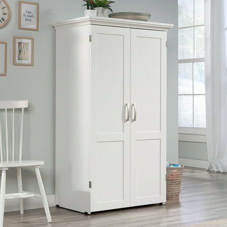 a white armoire next to a chair in a room