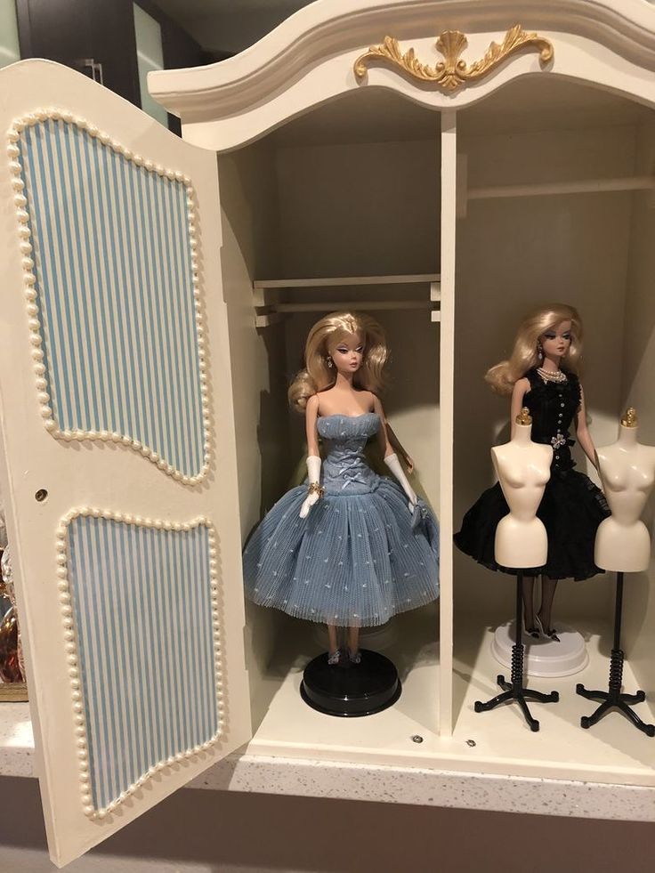 two barbie dolls are standing in a closet