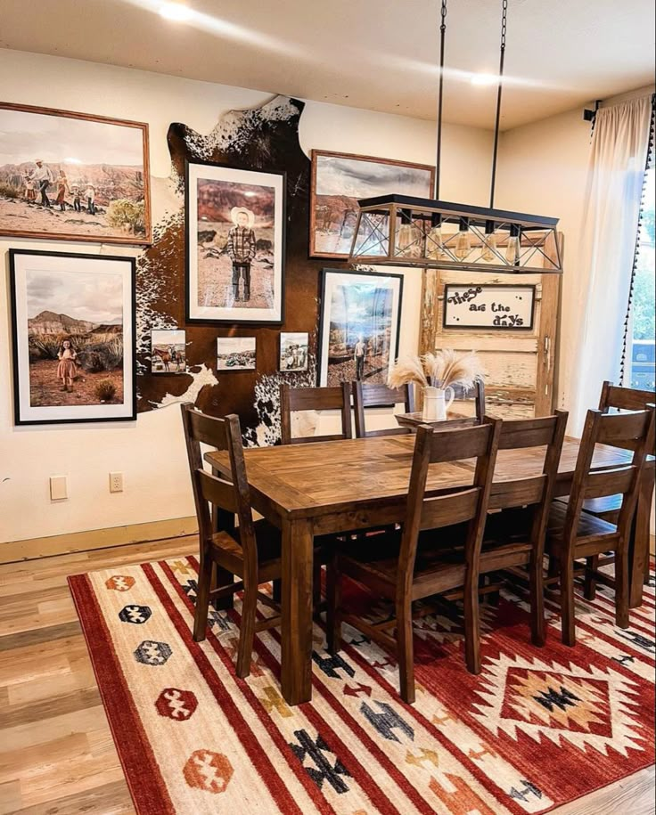 a dining room table with chairs and pictures on the wall