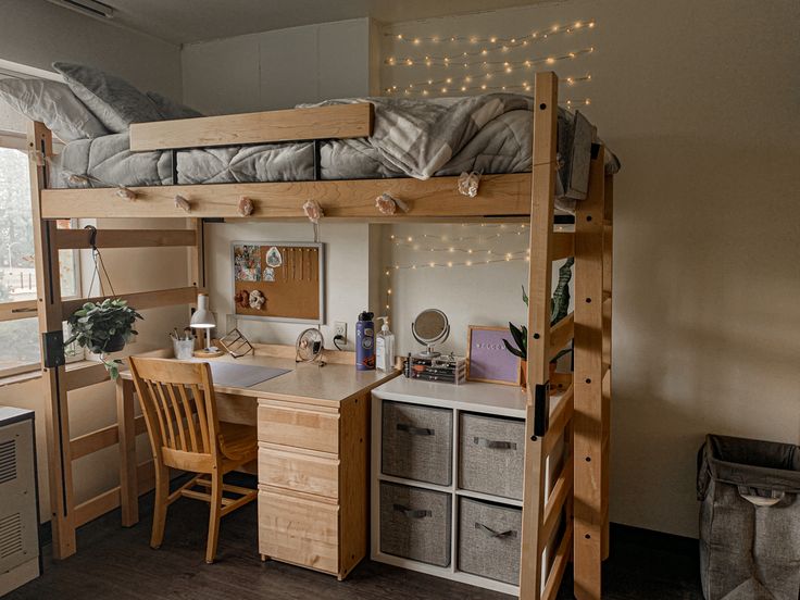 a loft bed with desk and chair in a small room next to an open window