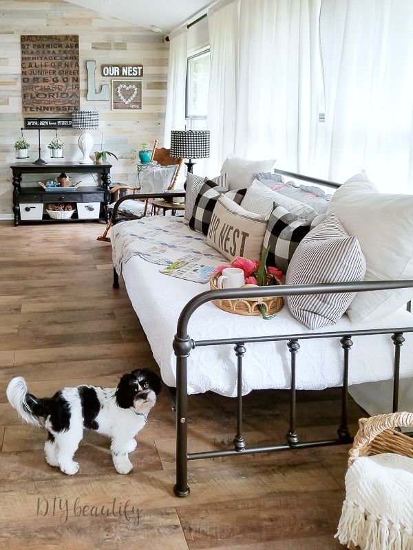 a black and white dog standing in front of a bed