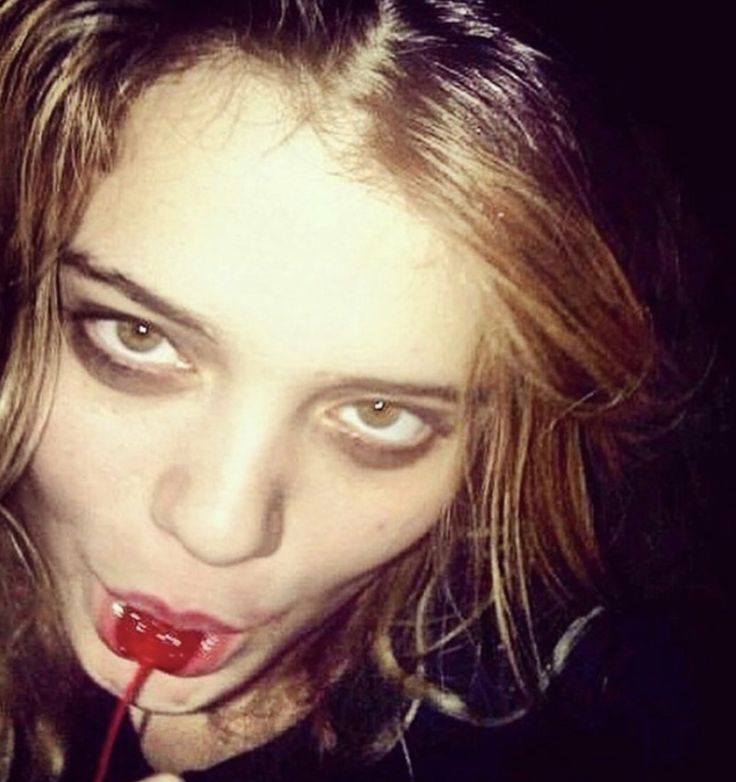 a woman holding a lollipop in her mouth