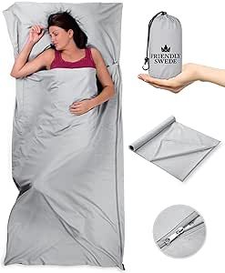 a woman laying in bed with a sleeping bag