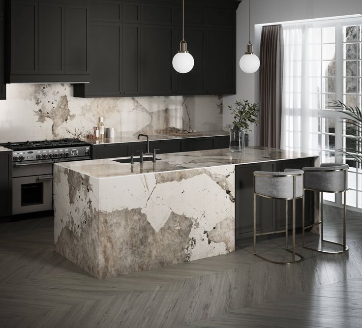 a kitchen with marble counter tops and black cabinets, along with an island in the middle