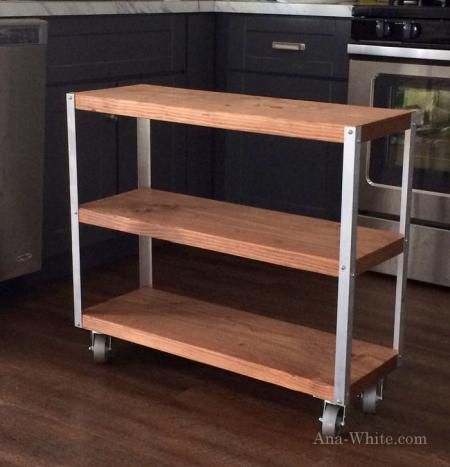 a kitchen with an oven, microwave and two shelves on the floor in front of it