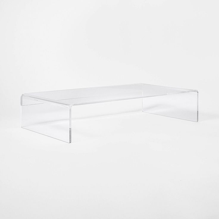 an acrylic coffee table is shown against a white background in this image, there are no people around it