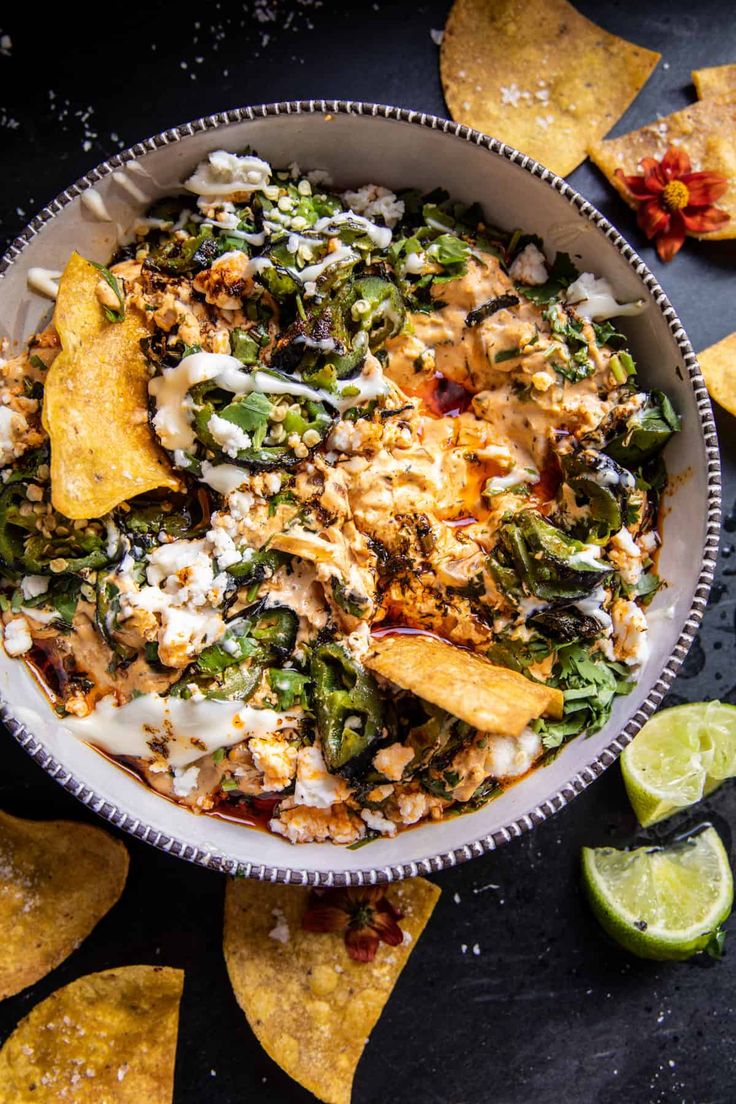 a plate filled with nachos and vegetables on top of a table next to a fork