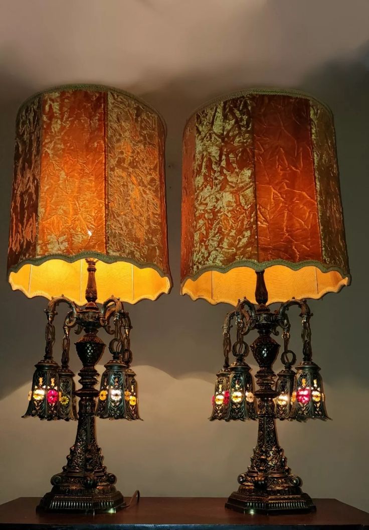 two lamps are sitting side by side on top of a table with a lamp shade