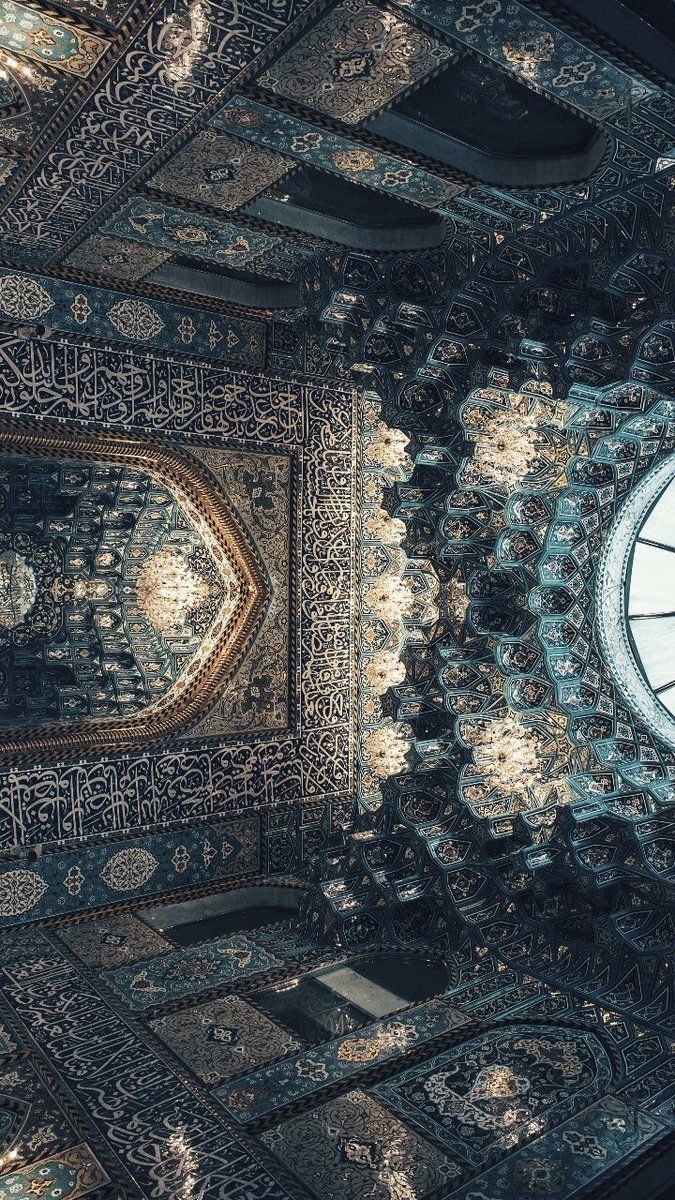 an intricately designed ceiling with a clock in the center