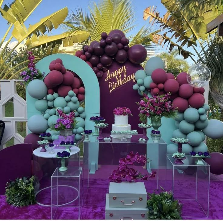 an outdoor birthday party with balloons and flowers