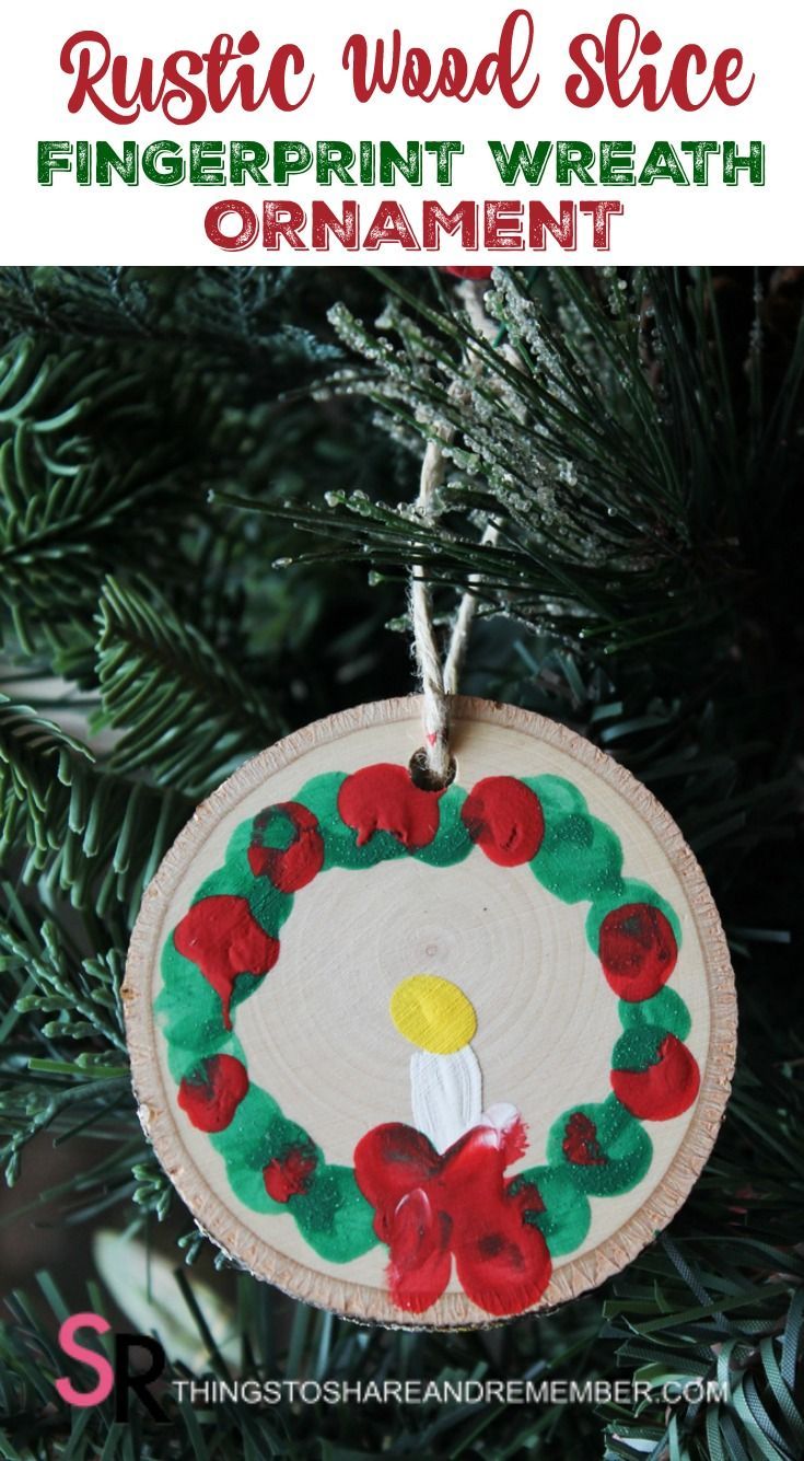 an ornament hanging from a christmas tree with the words, rustic wood slice fingerprint wreath ornament