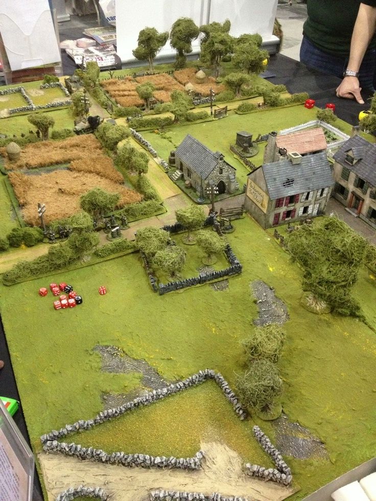 a table that has some model houses on it and people looking at the models in front of them