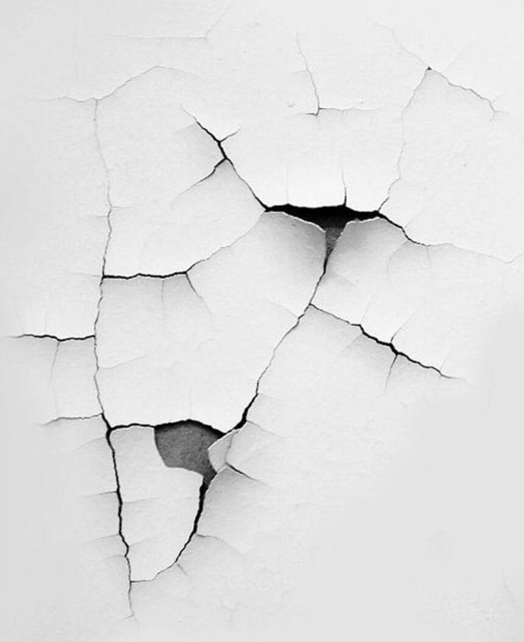 the cracks in the white wall are cracked and there is no image on it to describe