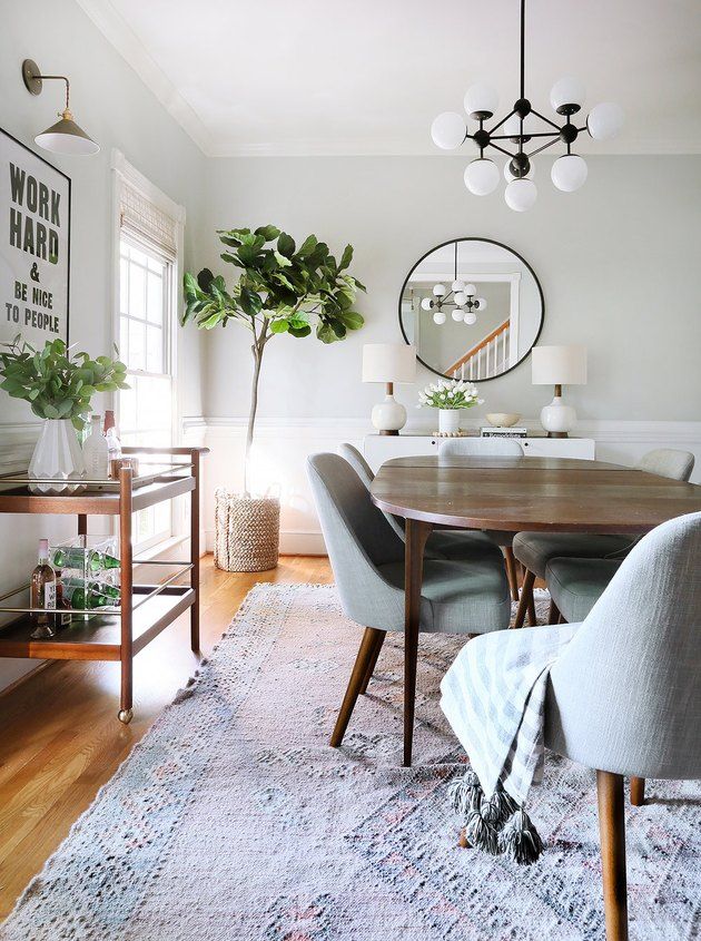 a dining room table with chairs and a rug on the floor in front of it