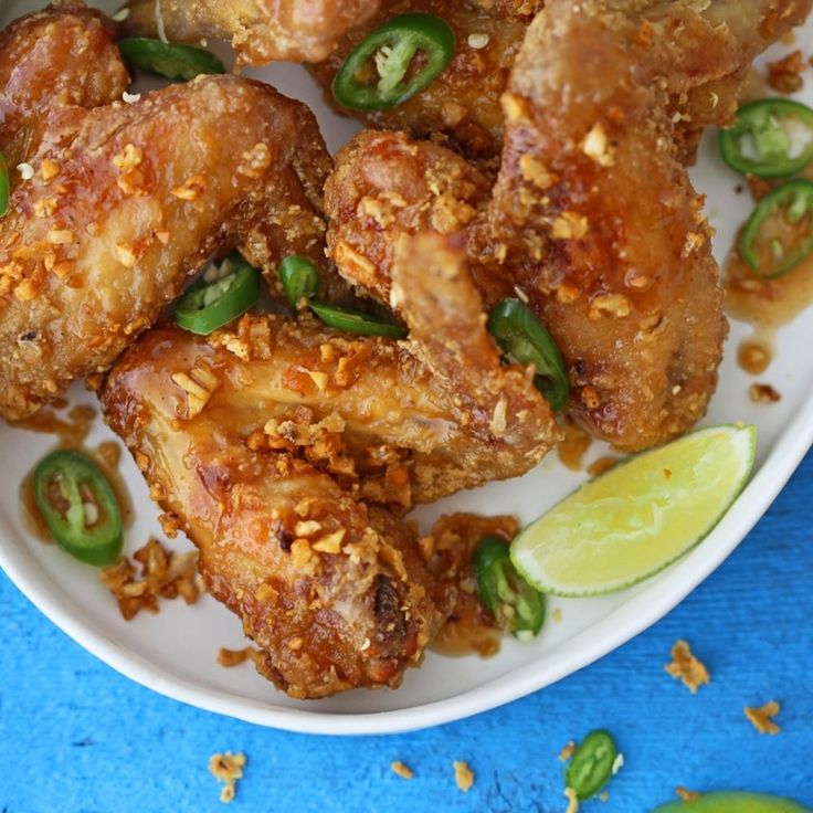 a white plate topped with fried chicken and green peppers