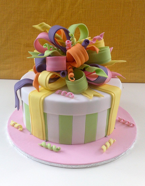 a birthday cake decorated with ribbons and bows