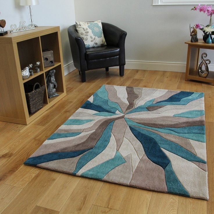 a living room filled with furniture and a rug on top of a hard wood floor