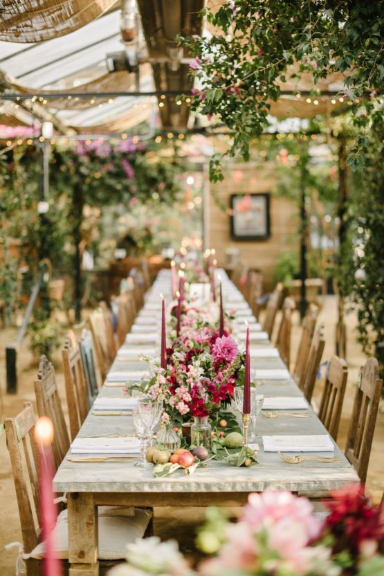 a long table is set with candles and flowers for a wedding reception in an old greenhouse