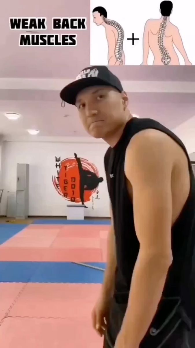 a man standing on top of a blue mat in a gym