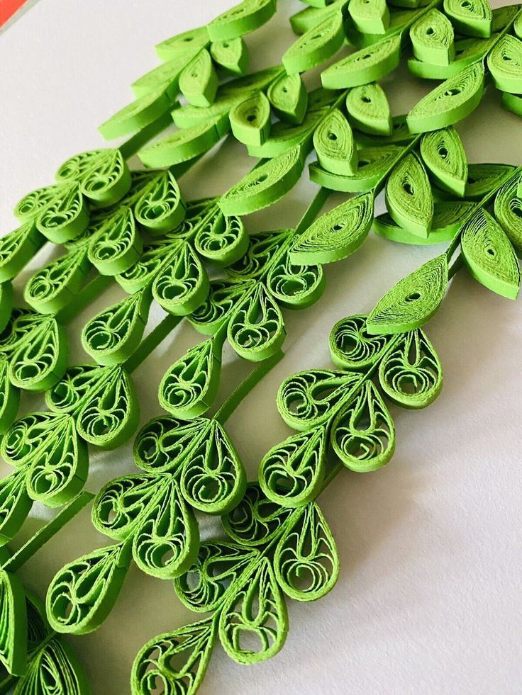 green paper quillings are lined up on a table