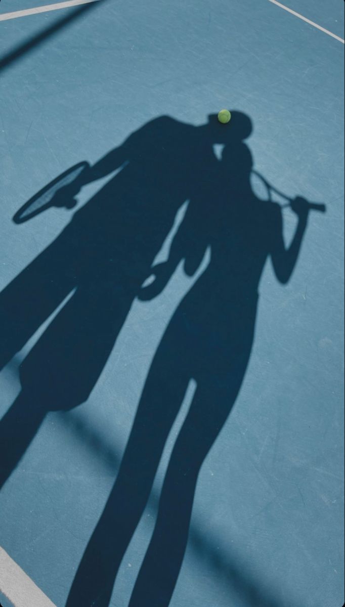 the shadow of a tennis player holding a racket