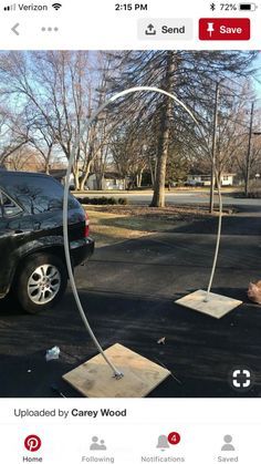 a car parked in front of a pole with a hose attached to it's side