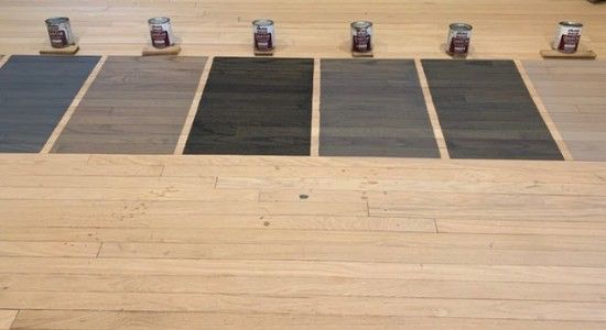 the floor is covered with different colors of wood and paint cans on top of them