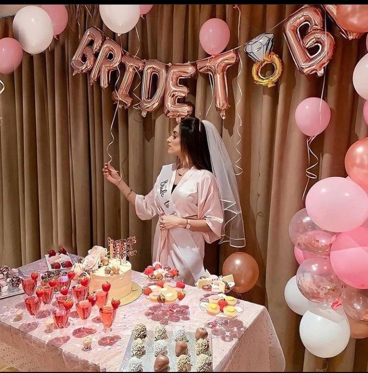 a woman standing in front of a table filled with cakes and desserts