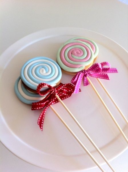 three lollipops on a plate with ribbons