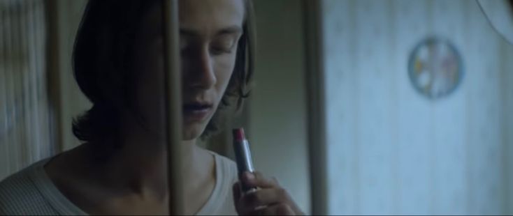 a woman holding a cell phone in her hand and looking at it through the bars