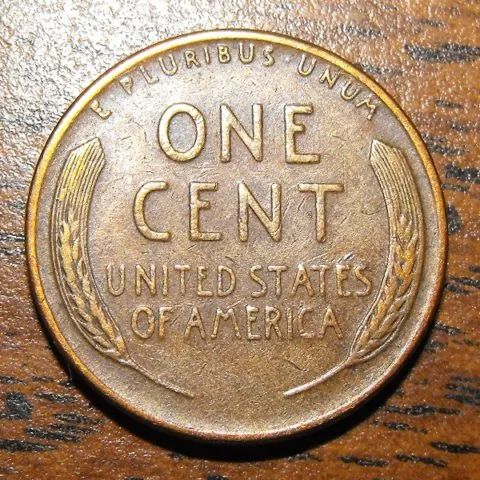 an old one cent coin sitting on top of a wooden table with the word, united states