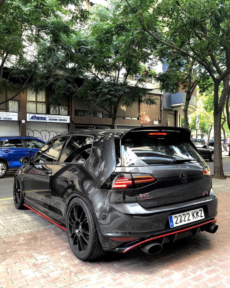 the back end of a black car parked in front of a building