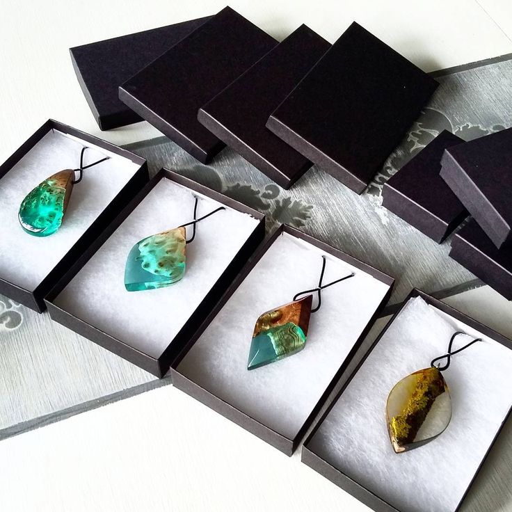 five different colored stones in black boxes on a table