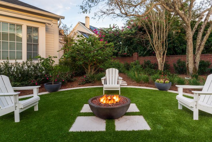 an outdoor fire pit surrounded by lawn chairs