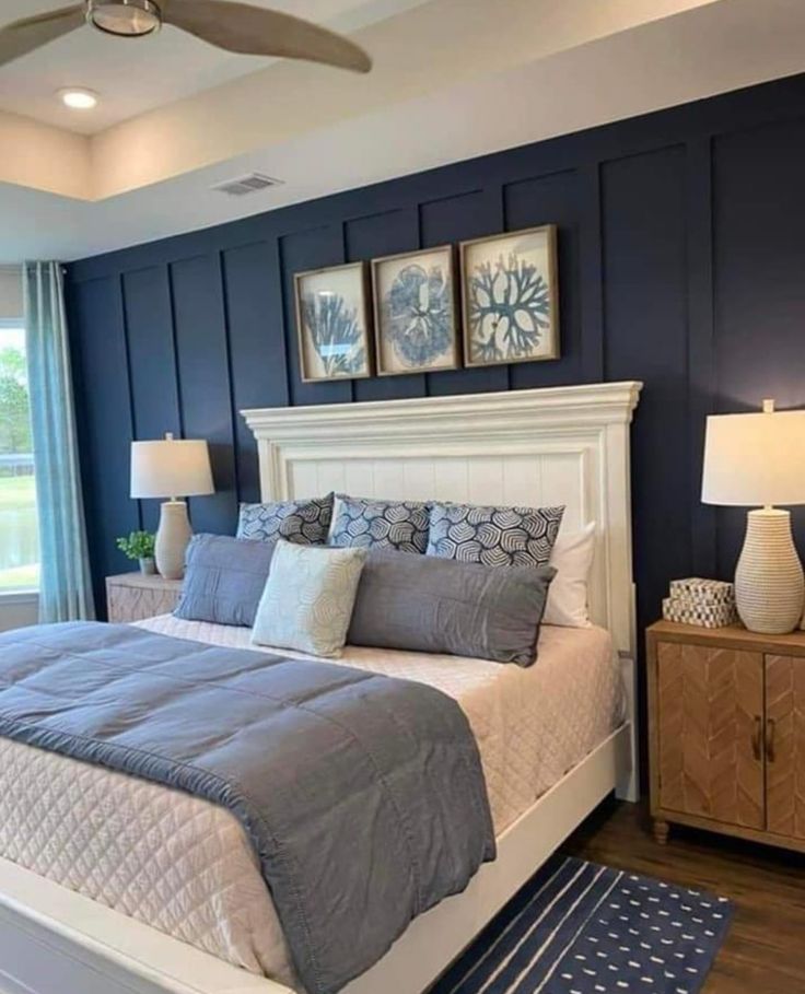 a bedroom with blue walls and white bedding